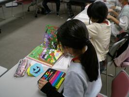 画像:机に向かい合ってかざりをつくる子ども司書